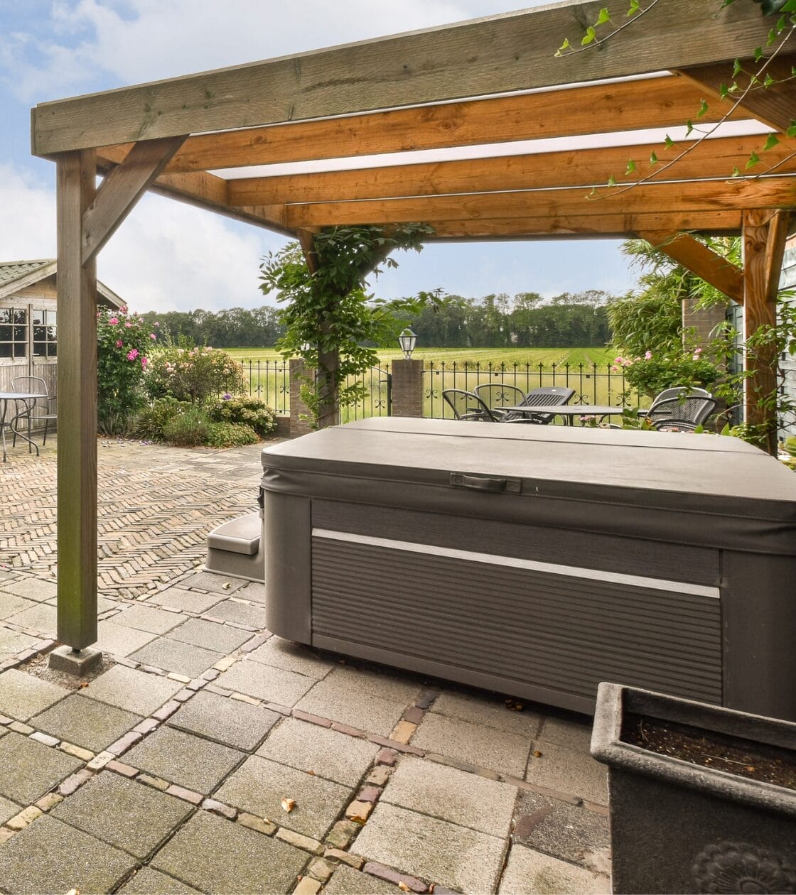 hot tub under a pergola on a beautiful back porch